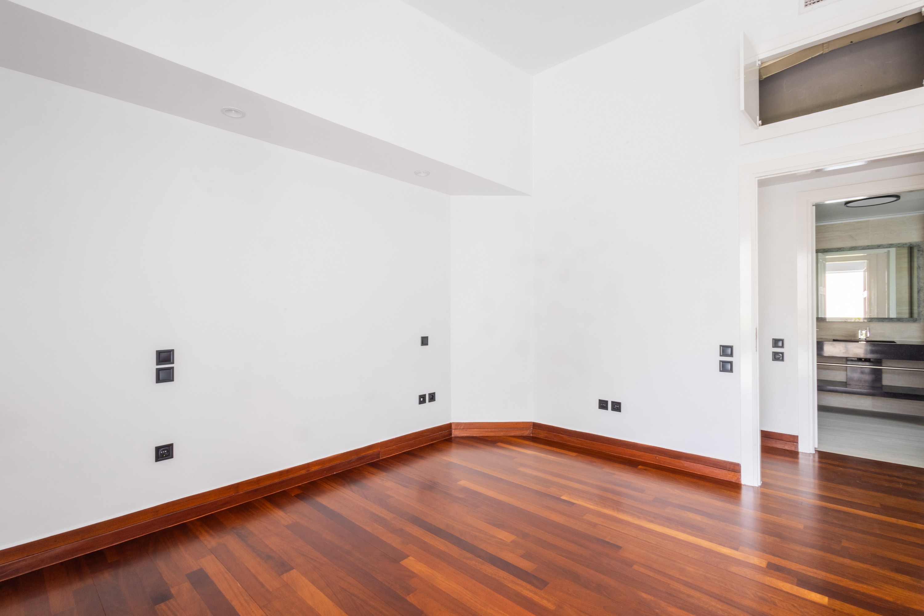 Bright third bedroom with timber flooring and direct en-suite access